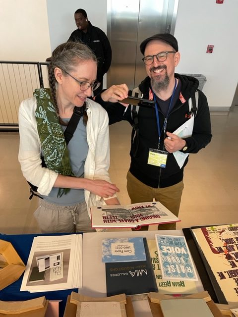Two visitors to the fair, Franklin and Karen Einspruch, examine Tom Virgin's collaboration with Edwidge Danticat, Food and Freedom, This Is My Body.